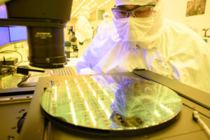 An Intel manufacturing technician at Fab 11X in Rio Rancho, New Mexico, inspects a 300-millimeter silicon wafer in January 2024